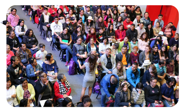 Fabiana Godínez interactúa con una audiencia diversa durante una conferencia sobre liderazgo y desarrollo personal.