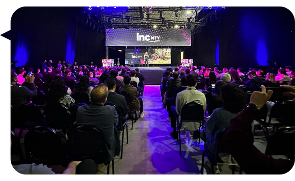 Fernanda Pérez Alarcón en el escenario de INC MTY, impartiendo una conferencia ante una audiencia numerosa en un ambiente iluminado y dinámico.